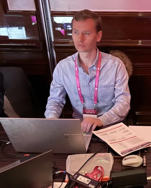 Olof working at a laptop behind an event desk.