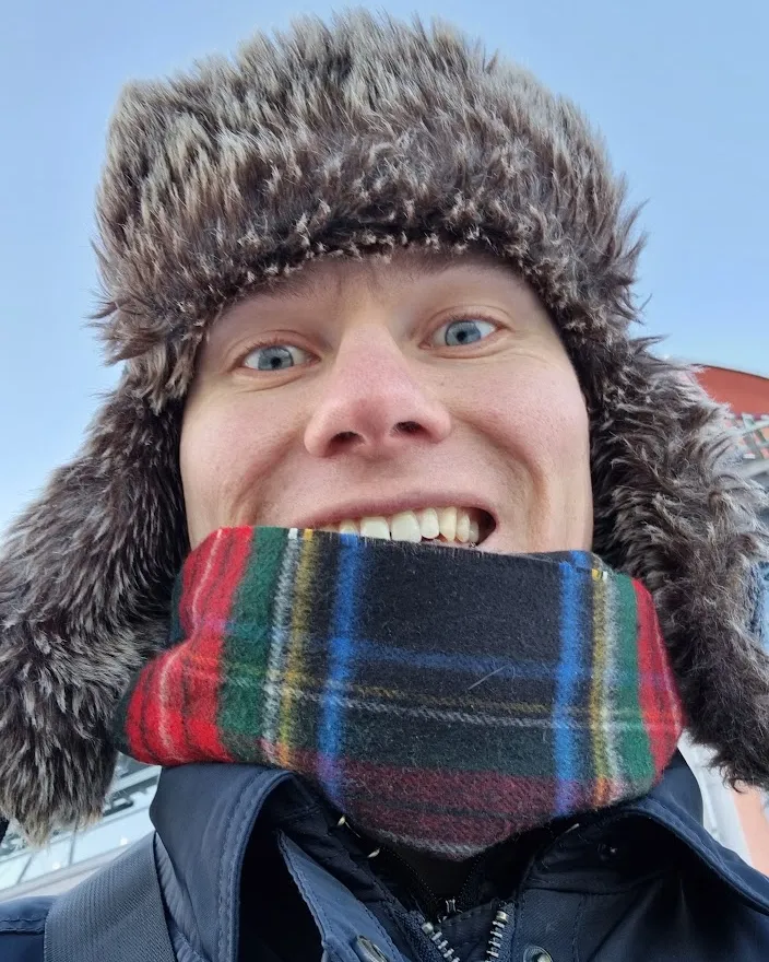 Olof wrapped in a scarf and a furry winter hat.